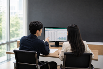 Two People in Office with Larger Screen and Nearby Window